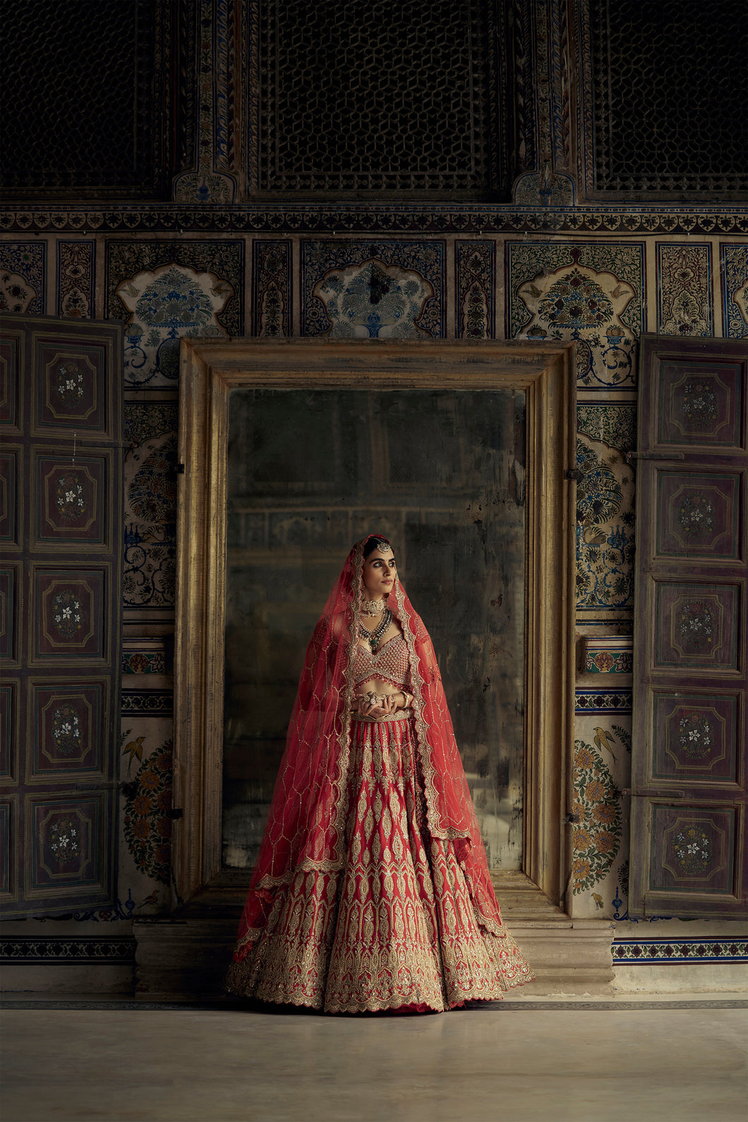 RED RAW SILK LEHENGA CHOLI SET WITH A HEAVY NET DUPATTA AND AN OPTIONAL WORKED BELT.