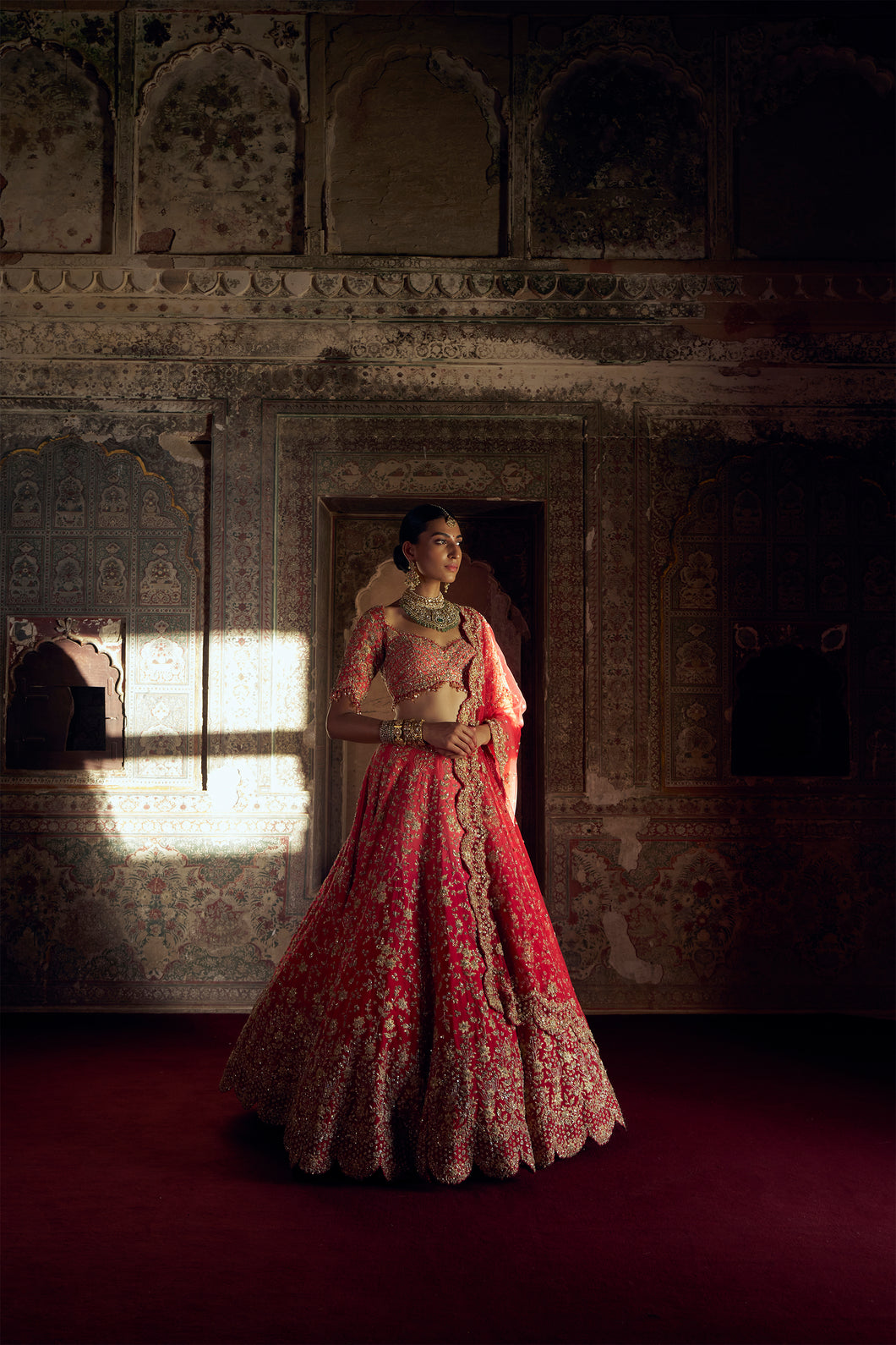 RED TO CORAL OMBRE DYED RAW SILK LEHENGA WITH A CORAL CHOLI AND RED DUPATTA AND A WORKED BELT.