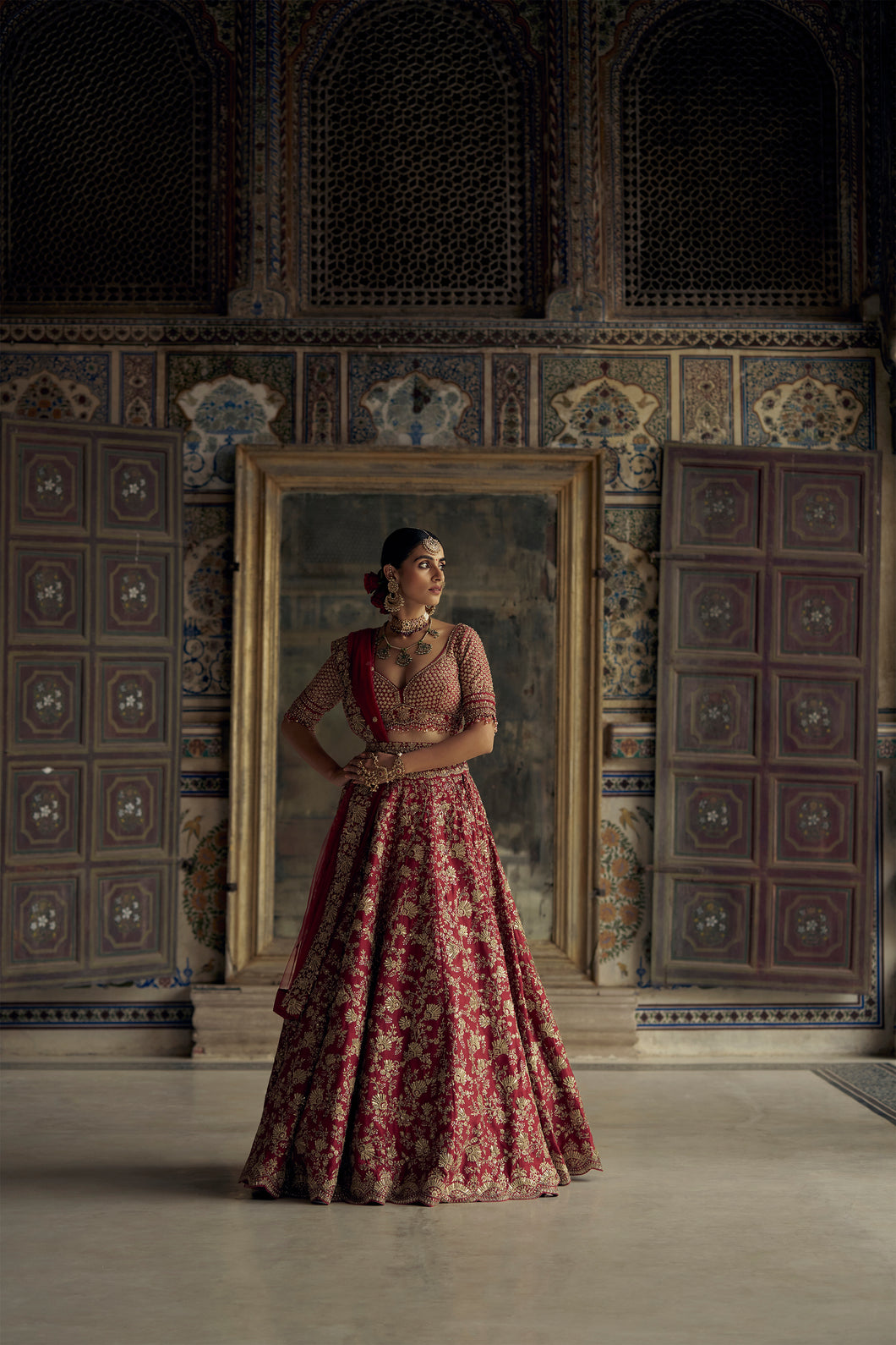 DEEP RED RAW SILK LEHENGA CHOLI WITH NET DUPATTA AND WORKED BELT.