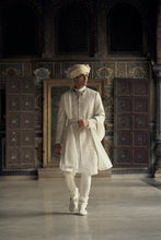 Load image into Gallery viewer, IVORY RAW SILK SHERWANI WITH KURTA AND CHURIDAR WITH AN OPTIONAL WORKED STOLE AND BELT AND EMBROIDERED JUTIS.
