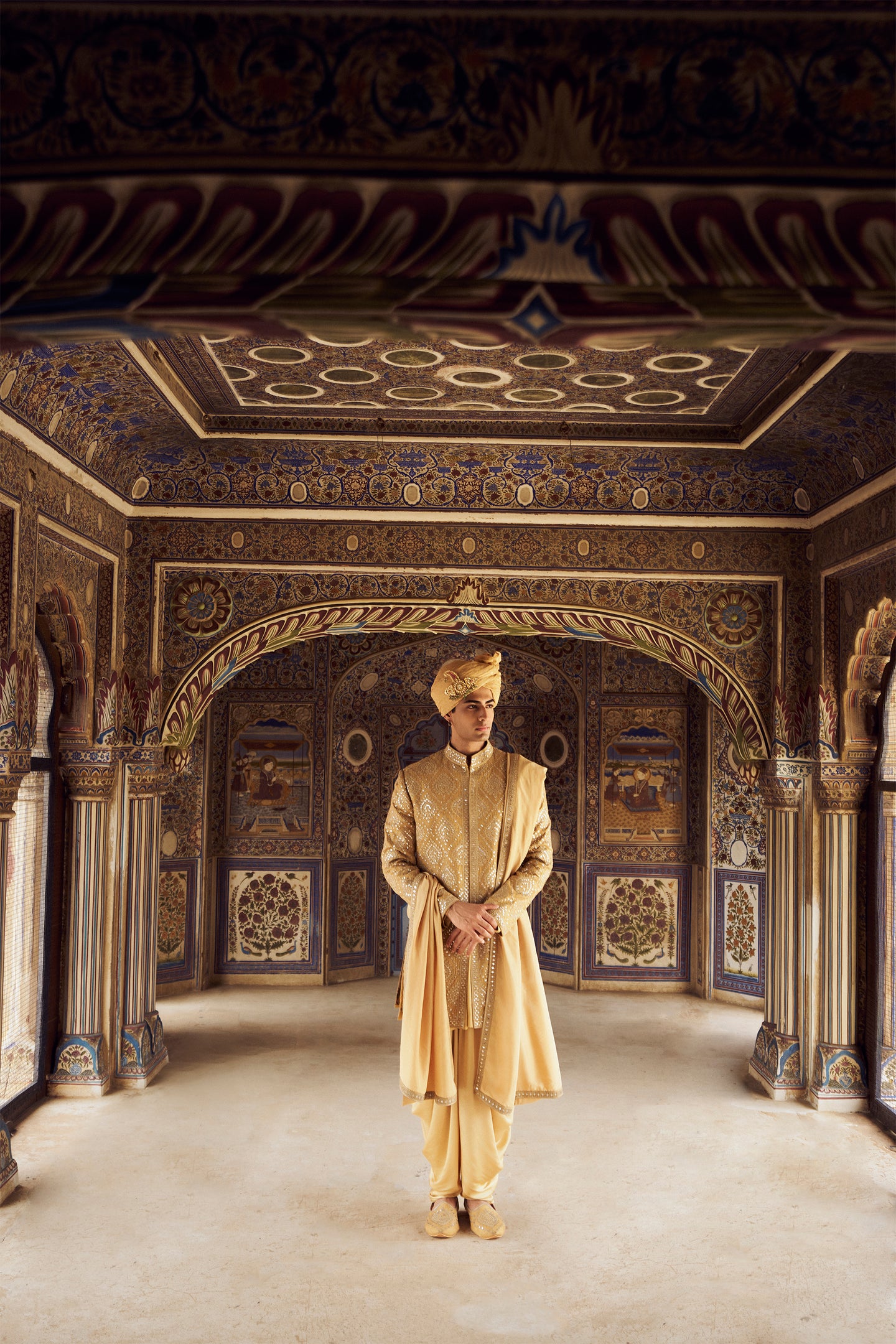 GOLD RAW SILK SHORT SHERWANI WITH A SATIN KURTA AND DHOTI WITH AN OPTIONAL WORKED STOLE AND JUTIS